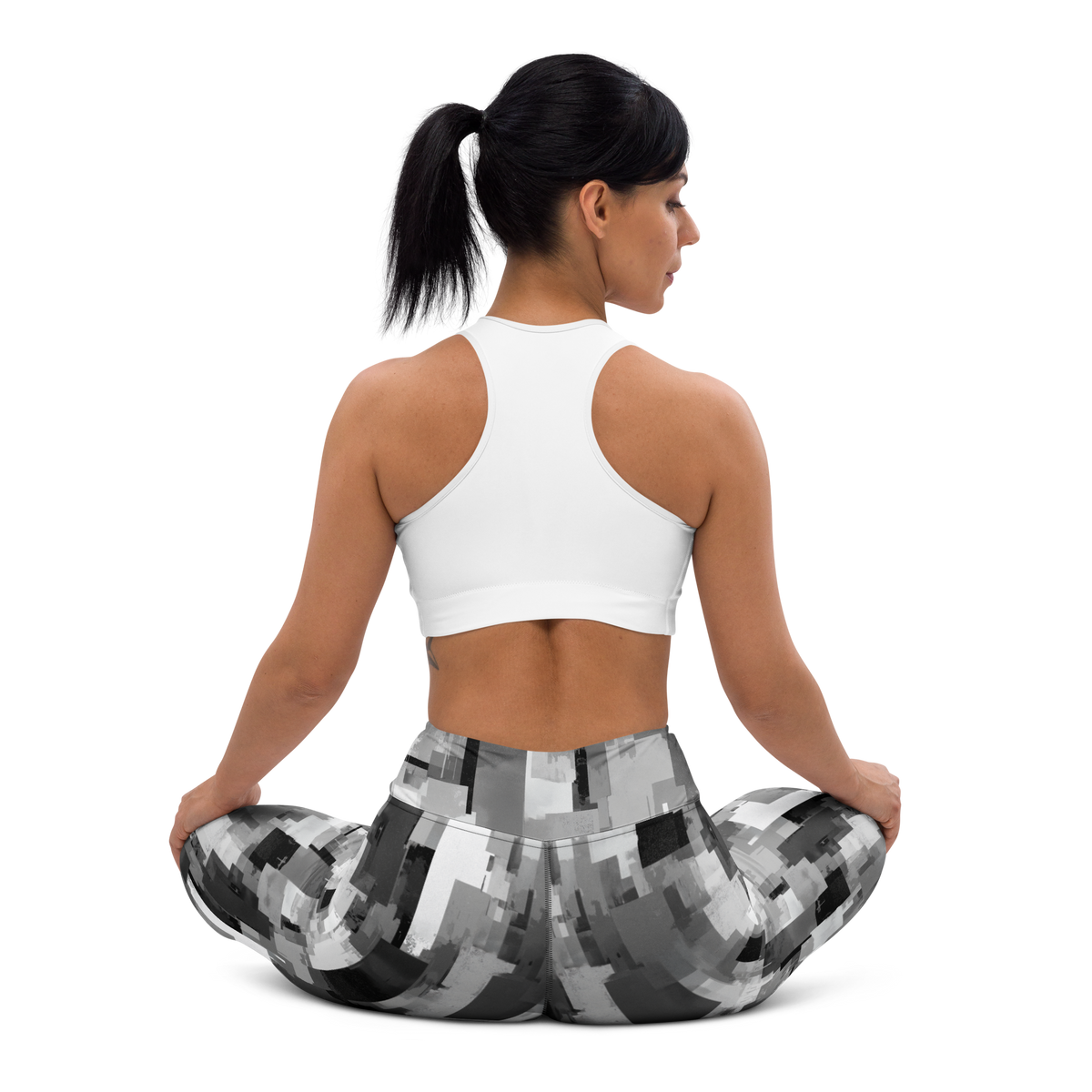 Statique Greyscale camouflage high-waisted yoga leggings, seated back view.